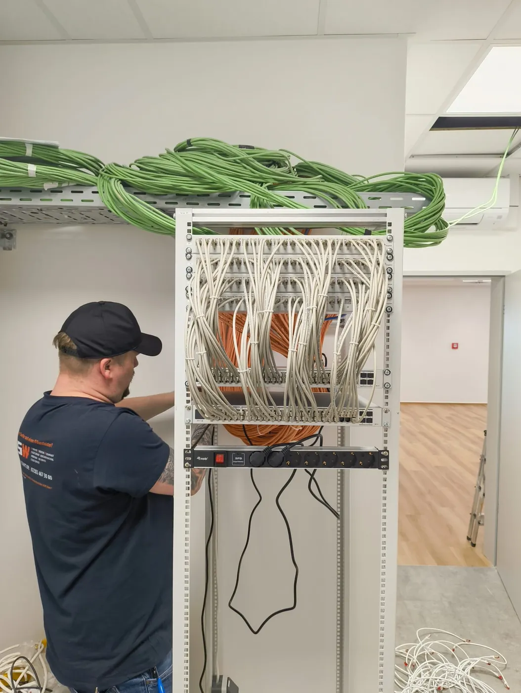 Mitarbeiter von CSW IT beim Auflegen der Patchkabel an einem Serverschrank